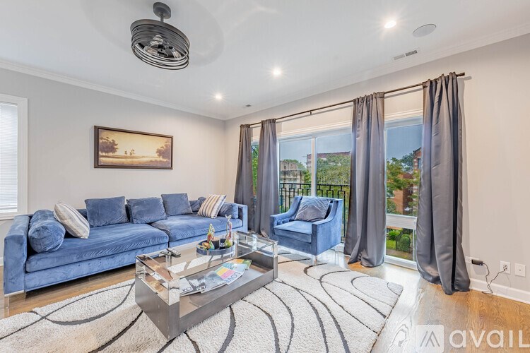 A living room with a blue couch, a coffee table, and a painting on the wall.