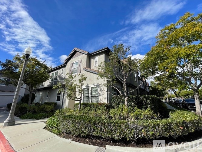 A house with a well-maintained front yard and a clear blue sky above.