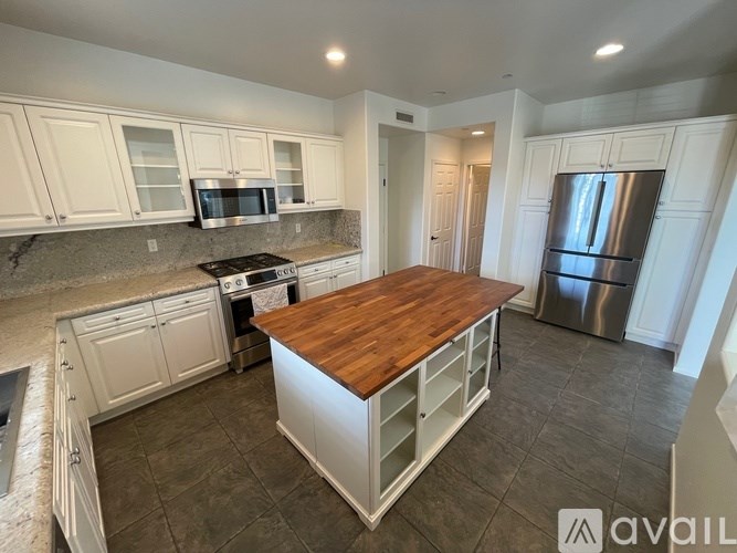 A kitchen with a wooden island in the middle.