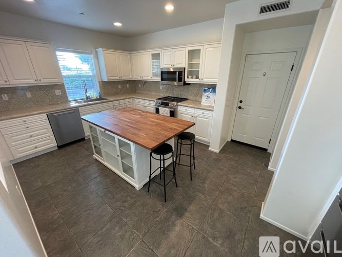 A kitchen with a wooden island and white cabinets.