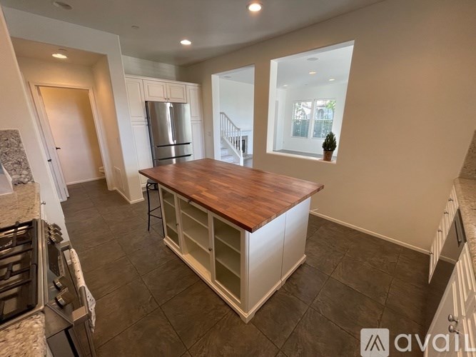 A kitchen with a wooden countertop and a stainless steel refrigerator.