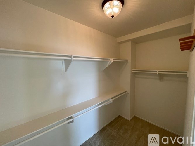 A room with white shelves and a light on the ceiling.