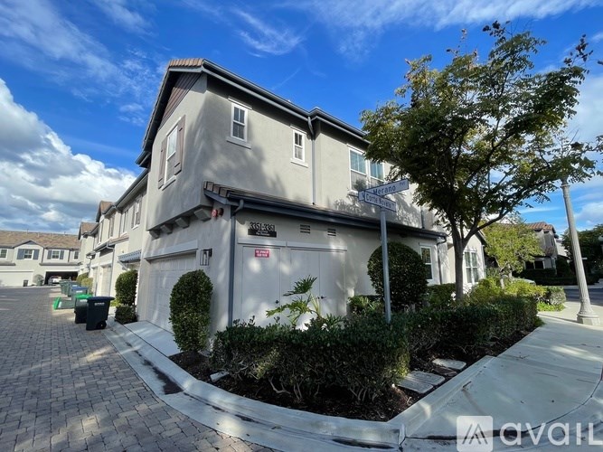A house with a driveway and a tree in front.
