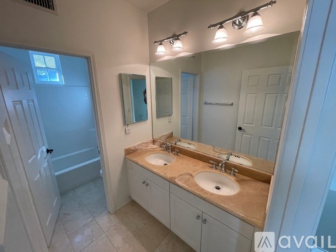 A bathroom with a double sink vanity and a large mirror.