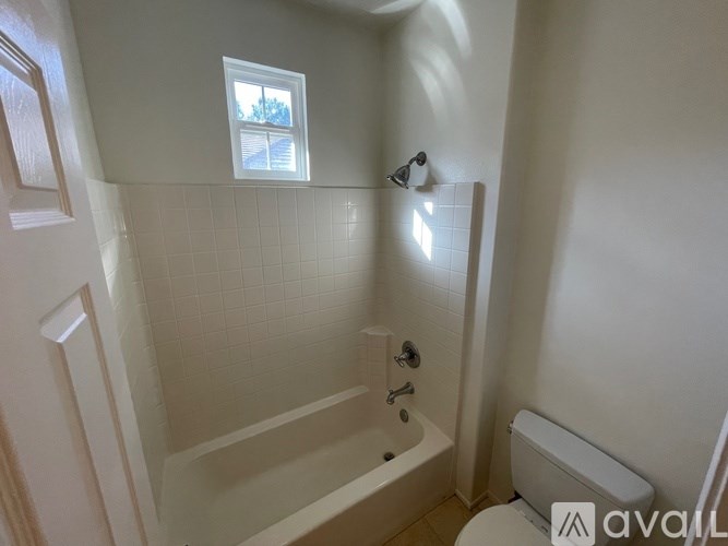 A bathroom with a white tub, toilet, and sink.