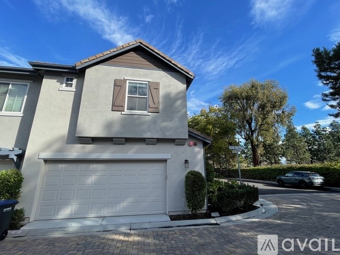 A house with a garage and a driveway in front of it.