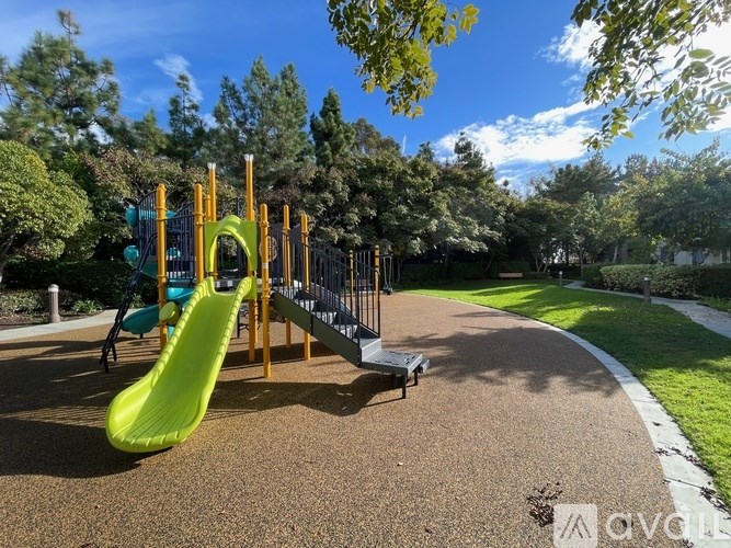A playground with a green slide and a yellow structure.