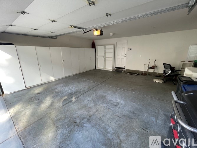 A large empty garage with a concrete floor and white walls.