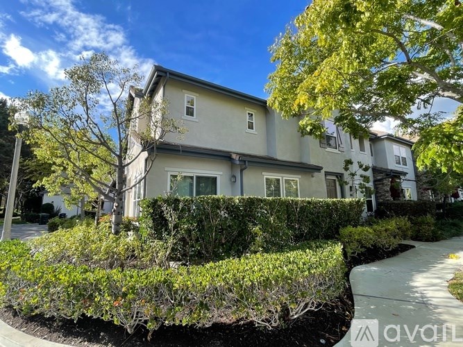 A house with a well-maintained hedge in front.