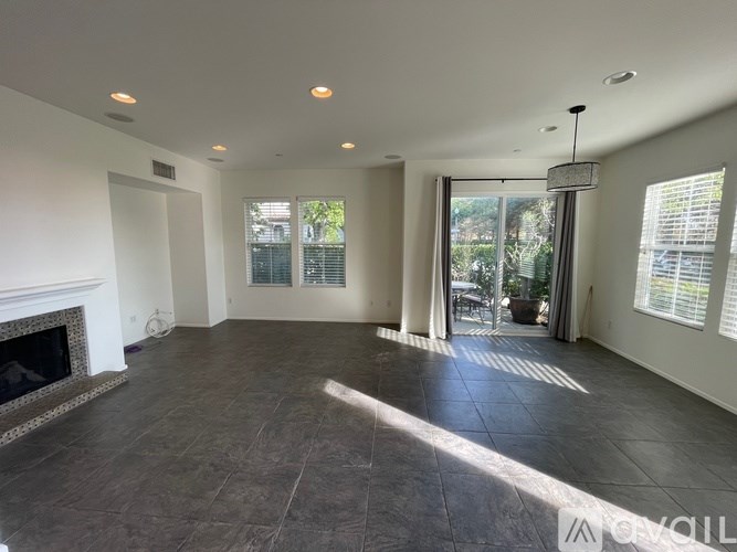 A spacious living room with a fireplace and large windows.