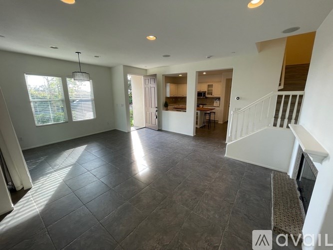 A spacious living room with a staircase leading to the upper floor.