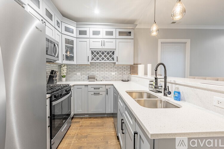 A modern kitchen with a stainless steel refrigerator and a white countertop.