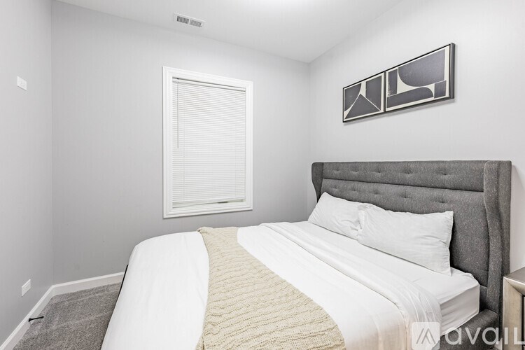 A bedroom with a large bed and a picture on the wall.