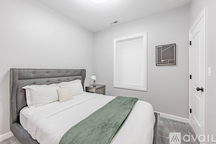 A bedroom with a large bed and a green throw blanket.