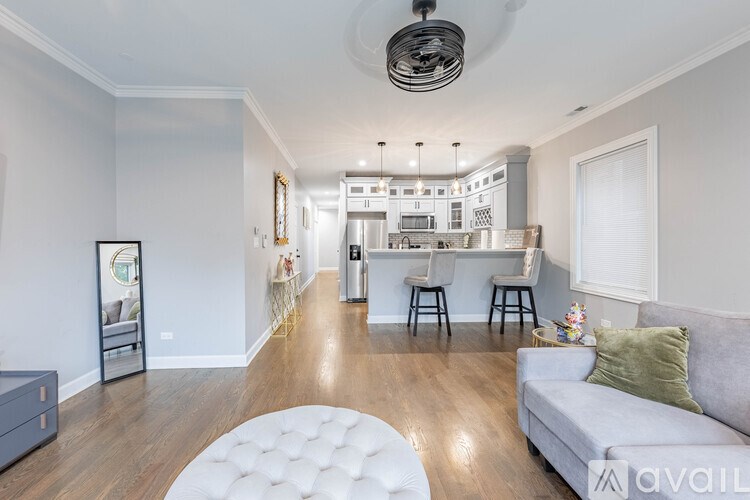 A modern living room with a grey sofa and a white ottoman.