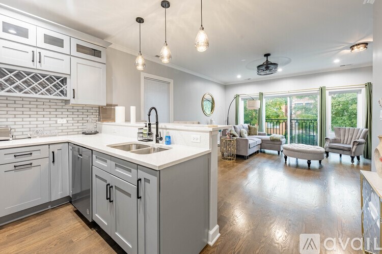 A kitchen with a white counter top and grey cabinets.