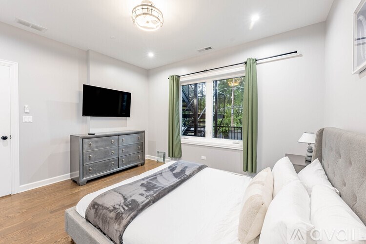 A bedroom with a large bed and a flat screen TV mounted on the wall.