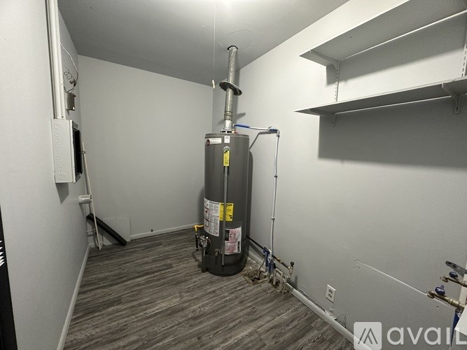 A room with a large black cylinder in the middle and a white wall.