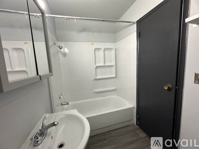 A bathroom with a white sink and bathtub.