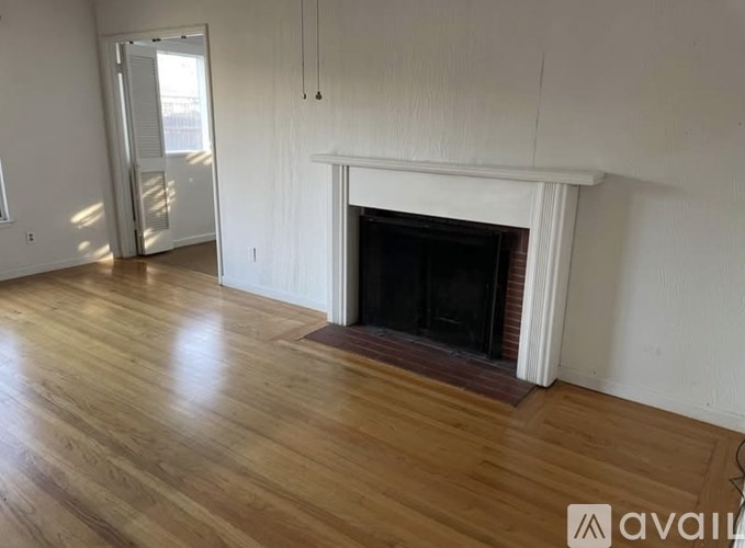 A room with a fireplace and wooden floors.