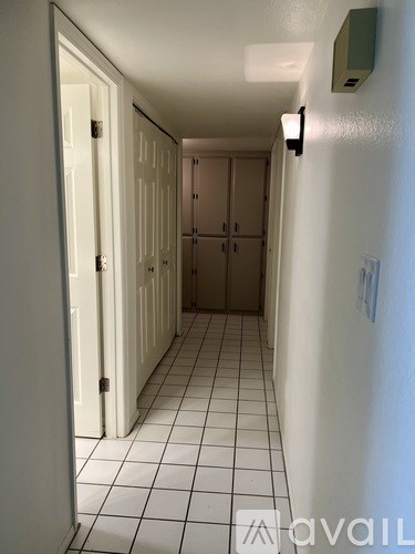 A hallway with white doors and tiled floors.