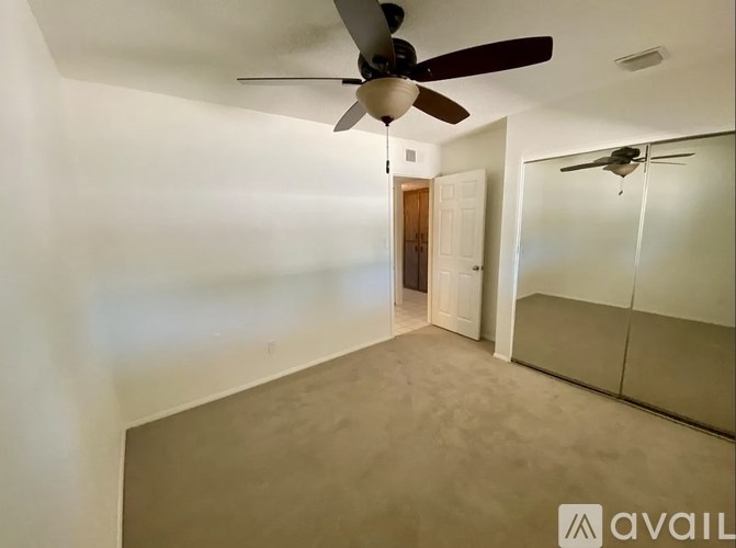 A room with a ceiling fan and a door.