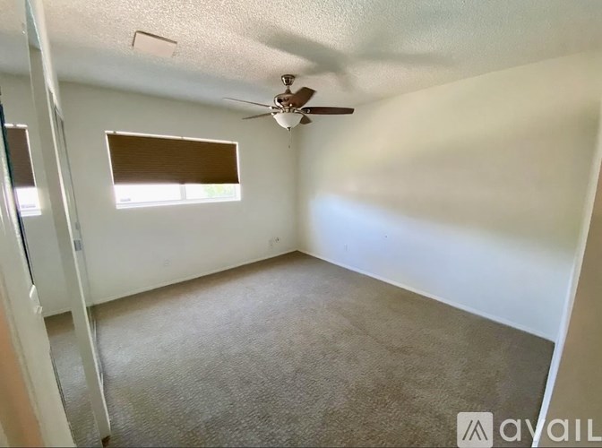 A room with a ceiling fan and a window.