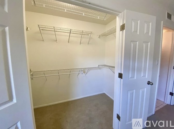 A white door is open to a room with a white wall and a white ceiling.