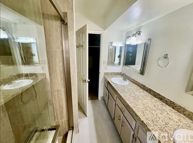A bathroom with a marble countertop and a large mirror.