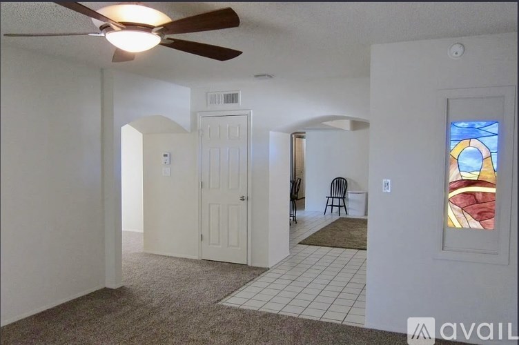 A room with a ceiling fan and a chair.