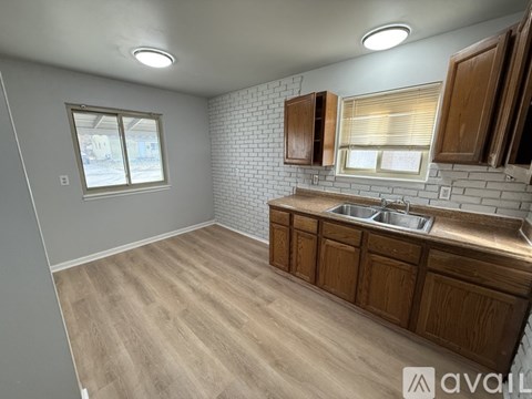 A kitchen with wooden cabinets and a brick backsplash.