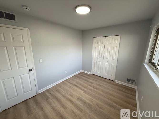 A room with a white door and a window with a white frame.