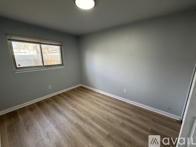 A room with wooden flooring and a window.