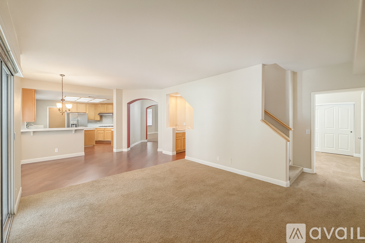 A spacious living room with a staircase leading to the upper floor.