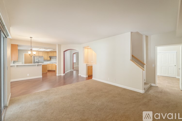 A spacious living room with a staircase leading to the upper floor.