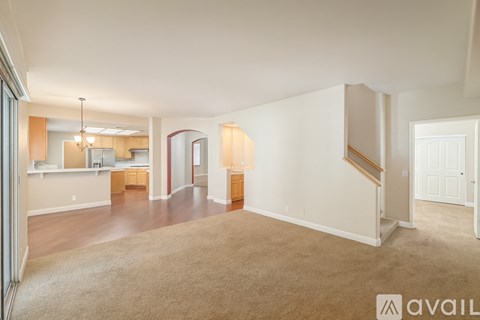 A spacious living room with a staircase leading to the upper floor.