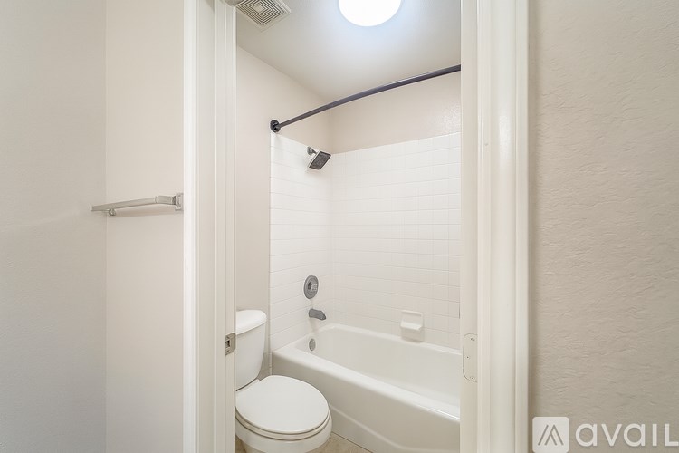 A white bathroom with a toilet, tub, and shower.