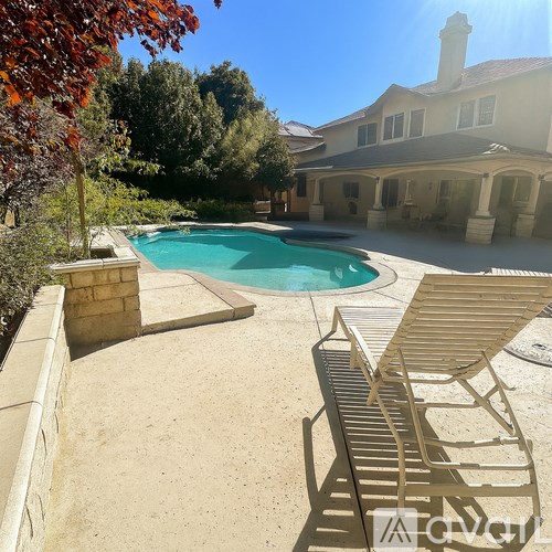 A pool surrounded by a patio and trees.