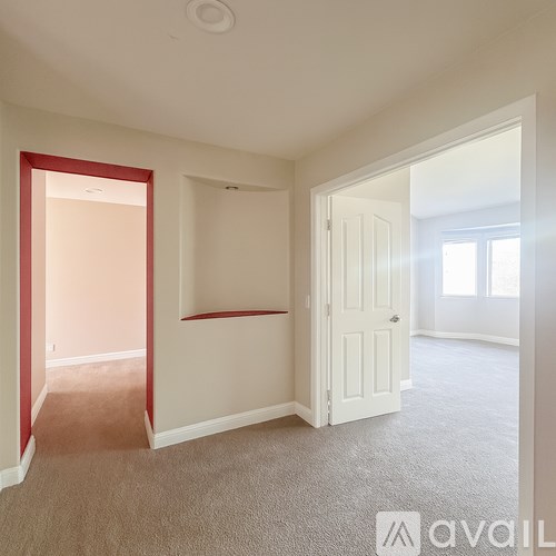 A room with a carpeted floor and a white door.