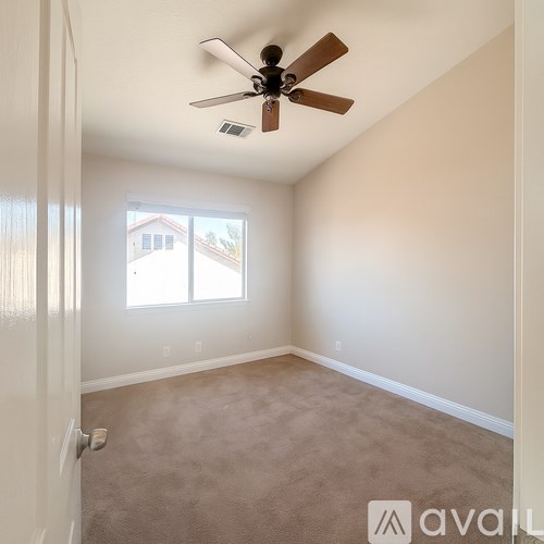 A room with a ceiling fan and a window.