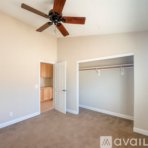 A room with a ceiling fan and a closet with a white door.