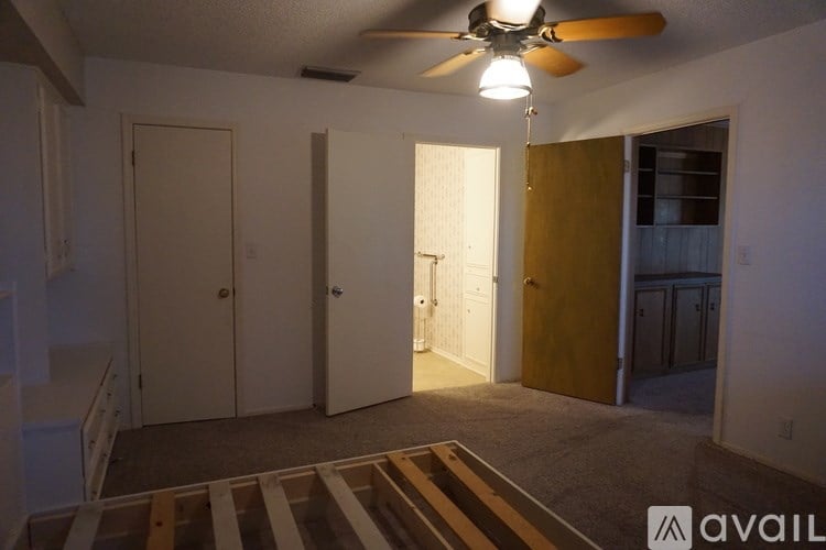 A room with a ceiling fan and a rug on the floor.