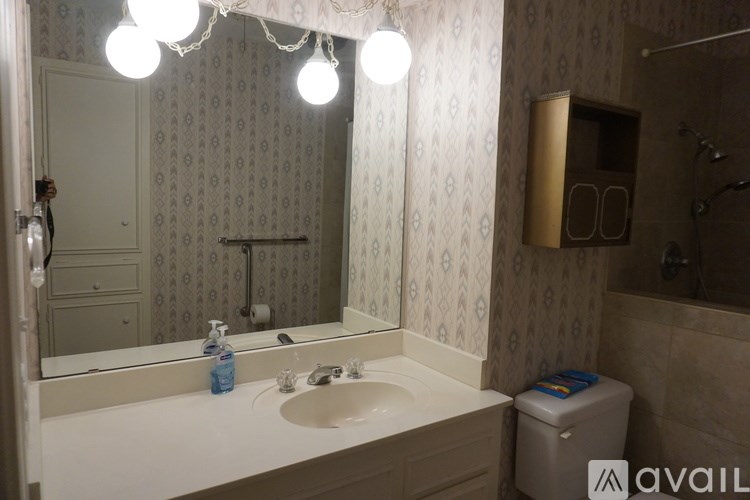 A bathroom with a sink, mirror, and toiletries.