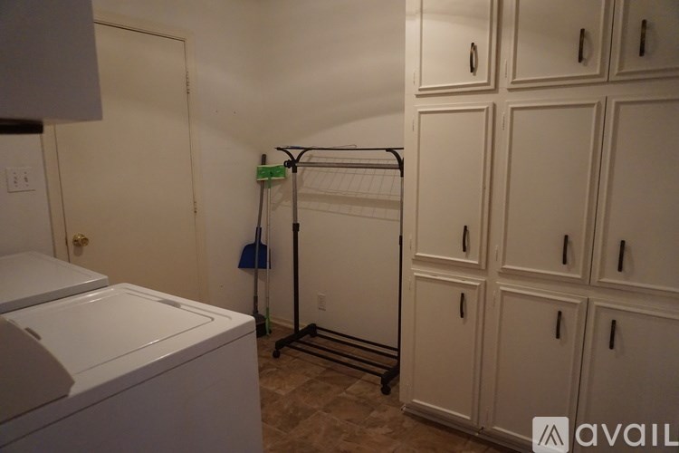 A laundry room with a washer and dryer and a mop rack.