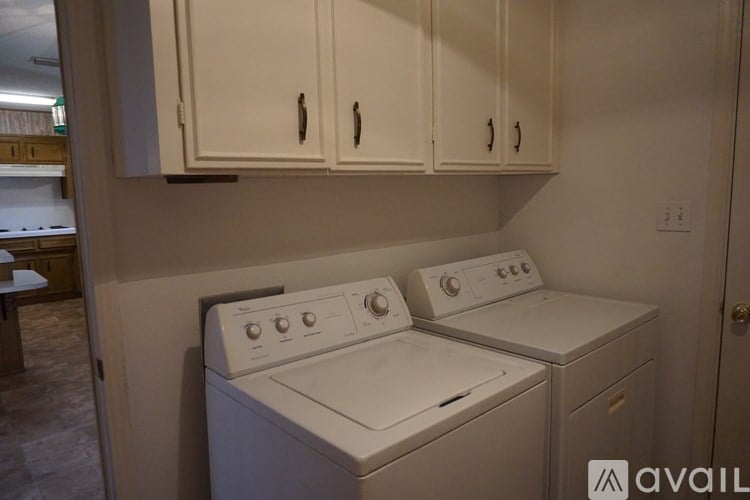 A white washer and dryer are installed in a laundry room.