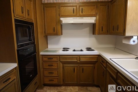 A kitchen with wooden cabinets and a white stove top.