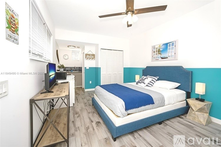 A bedroom with a bed, a television, and a ceiling fan.