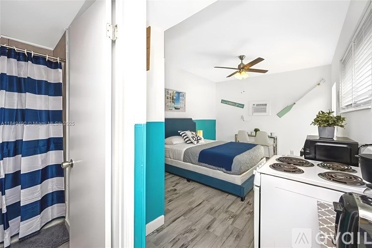 A blue and white striped shower curtain hangs on a white door.