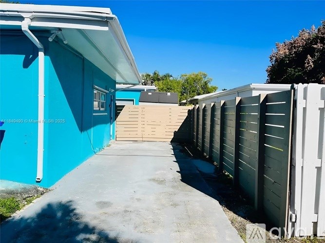 A blue and white building with a white fence in front.