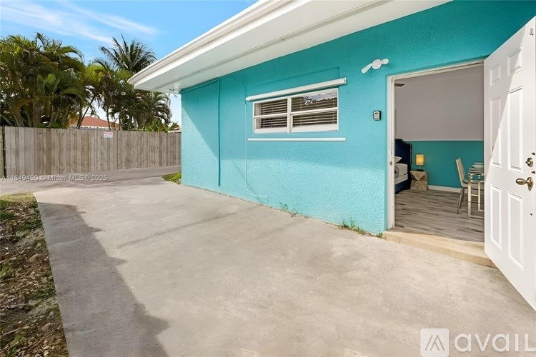 A blue house with a white door and a small patio area.